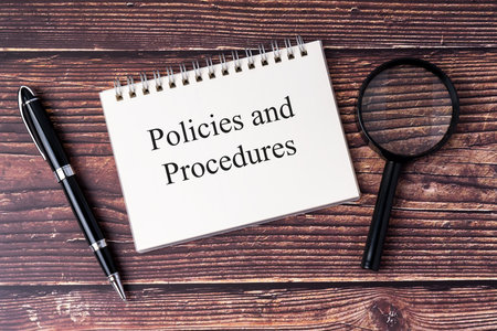Policies and procedures text on notepad flat layの写真素材