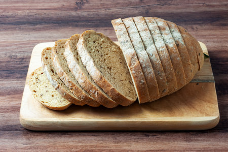 Loaf of multigrain bread on a wood trayの写真素材