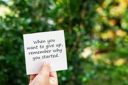 Hand holding a piece of paper with inspirational quotes - When you want to give up, remember why you started life quotesの写真素材