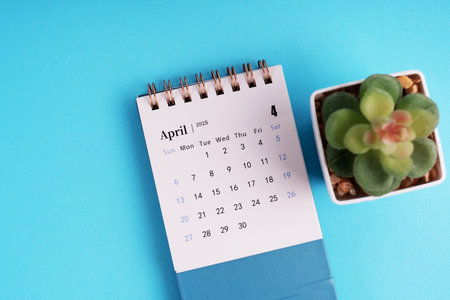 April 2025 desk calendar on blue backgroundの写真素材