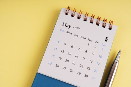 May 2025 desk calendar on yellow backgroundの写真素材