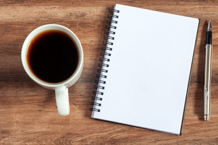 Blank notepad with cup of coffee and pen flat layの写真素材