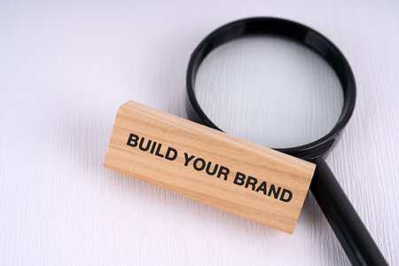 Magnifying glass and text build your brand text on wooden block business conceptの写真素材