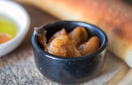 Macro photo of garlic confit served with ciabatta and olive oil