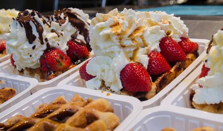 Belgian waffles with cream, berries and chocolate sauceの写真素材