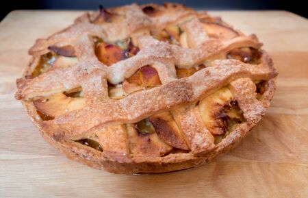 Macro photography of tasty apples and persimmons tart on wood cutting boardの写真素材