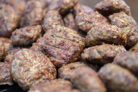Lot of hot grilled meatballs or small hamburgers