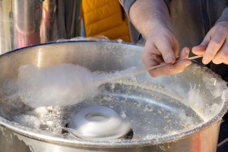 The male person prepare cotton candy at an outdoor marketの写真素材