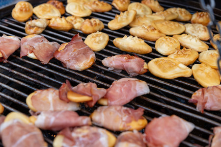 Traditional Polish street food, Oscypek - smoked sheep cheese with bacon on a grill, sold at the Christmas marketの写真素材