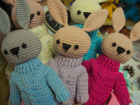 Three knitted bunny or rabbits in sweaters toysの写真素材