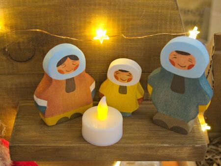 Wooden eskimo family near the candle figurine on wooden shelf の写真素材