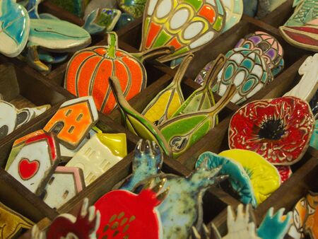 Painted ceramic signs and figurines in form of vegetables, leaves and cabins.の写真素材