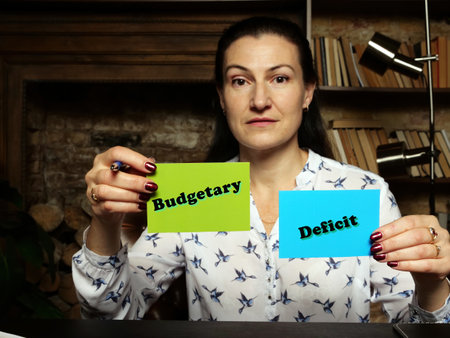 BusinessWoman holding a blank business cards. Business concept about Budgetary Deficit with phrase on the sheet.の写真素材
