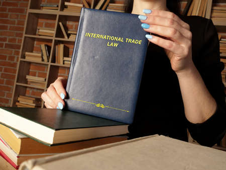 INTERNATIONAL TRADE LAW book in the hands of a attorney. International trade law includes the rules and customs governing trade between countriesの写真素材