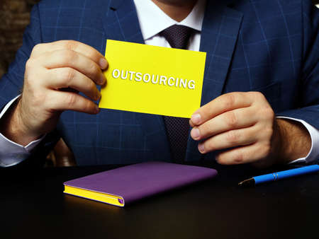 Financial concept meaning OUTSOURCING with sign on the sheet. Business concept about the business practice of hiring a party outside a company to perform servicesの写真素材