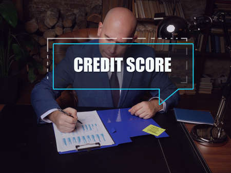 CREDIT SCORE phrase on the screen. Manager analyzing market research results. A credit score is a numerical expression based on a level analysis of a person's credit filesの写真素材