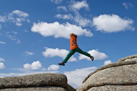 The person jumping on background blue sky in mountainsの写真素材