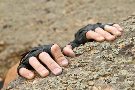 Hands of the climber hanging on rock. Finger are covered by talc.の写真素材