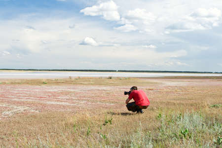 The man photographs sitting on the natureの写真素材