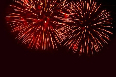 Two bright flashes of salute against the night sky located in the top part of a shot