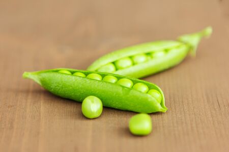 Beautiful peas with the chosen focus on wooden background