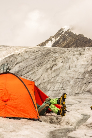 The climber lies in tent of mountain camp against beautiful topの写真素材