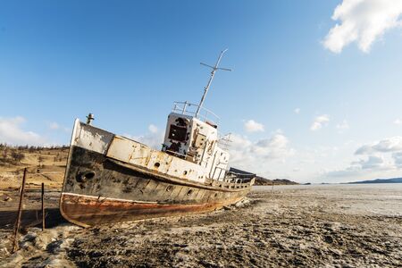 The old thrown ship froze in dirty iceの写真素材