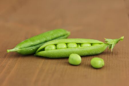 Beautiful peas with the chosen focus on wooden backgroundの写真素材