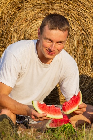 The person eats an outdoors sweet and tasty water-melonの写真素材