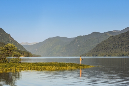 The fisherman in summer day on the bank of the lakeの写真素材