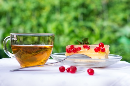 Cup of tea with tasty cake on table in gardenの写真素材