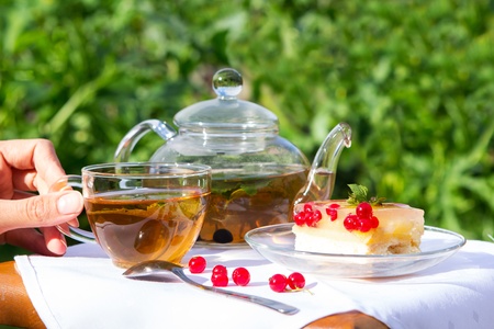 Fine dessert with tea a background of green gardenの写真素材