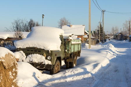 Abandoned roken-down machine in the snow in the countrysideの写真素材