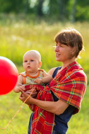 The child with mother in summer field walk togetherの写真素材