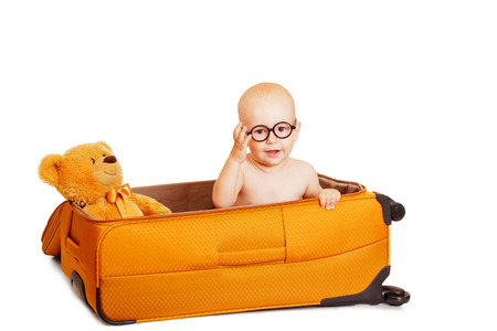 The child with toys with round points sits in suitcaseの写真素材