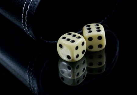 Two standard six-sided pipped dice with rounded corners on black background.の写真素材