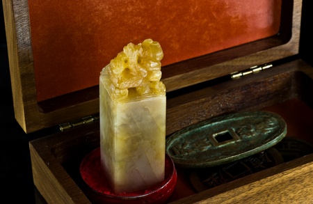 Curio box with Chinese alabaster stamp and ancient coins.の写真素材