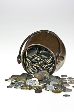 Old copper pot with coins on whiteの写真素材