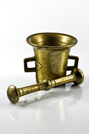Old brass mortar with pestle on whiteの写真素材