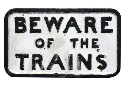 Old sign on railway track warning of trainsの写真素材