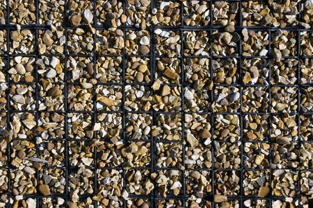 Small stones packed together in small plastic squares for outdoor flooringの写真素材
