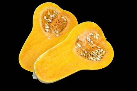 Butternut vegetable cut in half showing the bright orange flesh and seedsの写真素材
