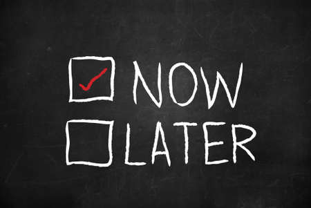 Now and Later check boxes on blackboardの写真素材