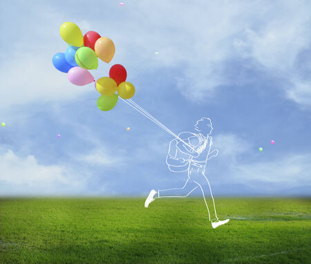 walking while holding colored balloonsの写真素材