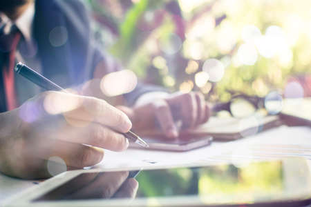 Selective focus Hand writing blank paper on wooden work space with soft flare filter and cross process creative and Business conceptの写真素材