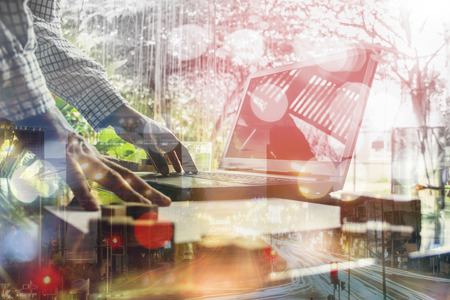 Business man working at office with laptop and documents on his desk .Mixed mediaの写真素材