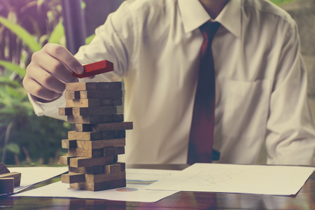 Planning  risk and strategy in business  businessman and engineer gambling placing wooden blockの写真素材