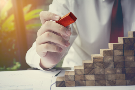 Planning, risk and strategy in business, businessman and engineer gambling placing wooden blockの写真素材