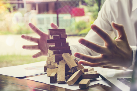Problem Solving,business can't stop effect of dominoes continuous toppled with hand at deskの写真素材