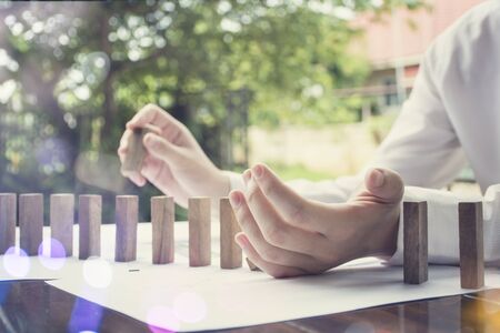 Concept of building success foundation. Businessmen hand put wooden blocks in the shape of a staircaseの写真素材